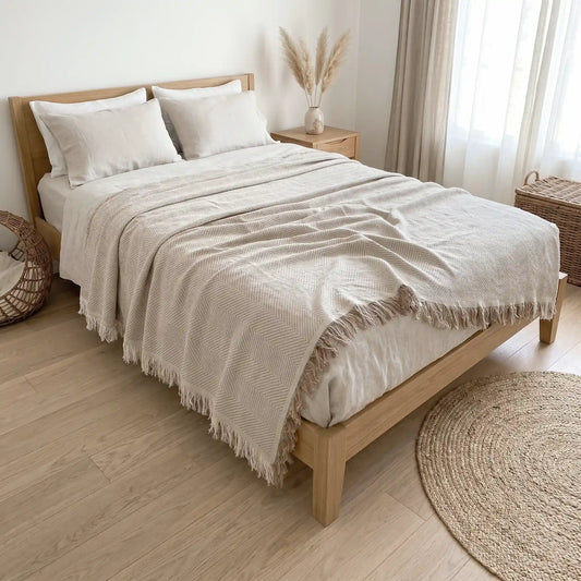 Colcha de verano multiusos color beige extendida sobre una cama. Tejido ligero y transpirable 80% algodón, ideal para decorar dormitorios luminosos.