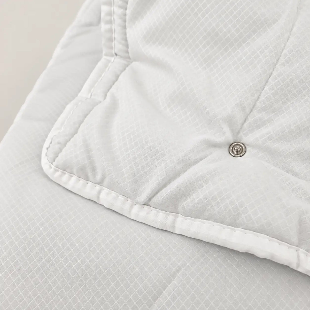 Détail du système de boutons-pression de la couette Eco pour la fixer au modèle 100 g et créer une couette 4 saisons. - Oma Home