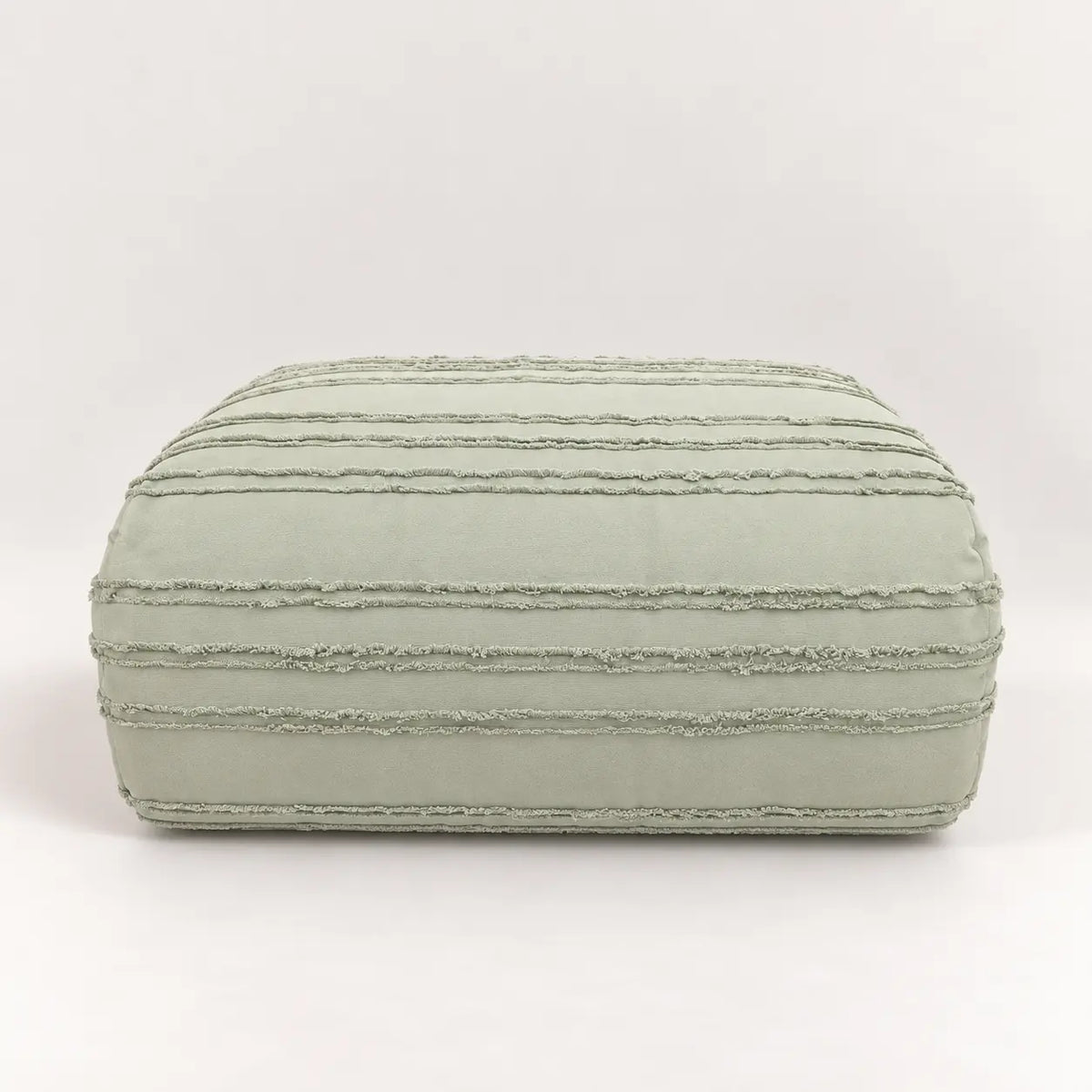 Primer plano del tejido de microfibra verde, mostrando el detalle decorativo de las finas rayas en relieve con acabado texturizado.