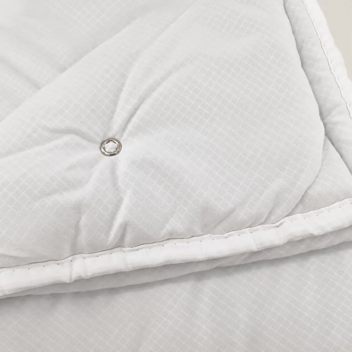 Gros plan du tissu ultra-doux au toucher nuage de la couette de mi-saison d’Oma Home. - Oma Home