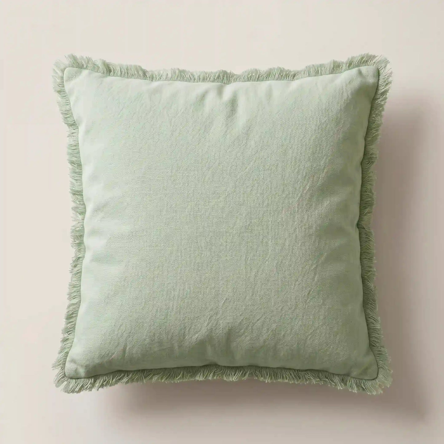 Funda de cojín verde suave 45x45cm de 100% algodón con detalles de flecos de Oma Home. Diseño natural para sofá.