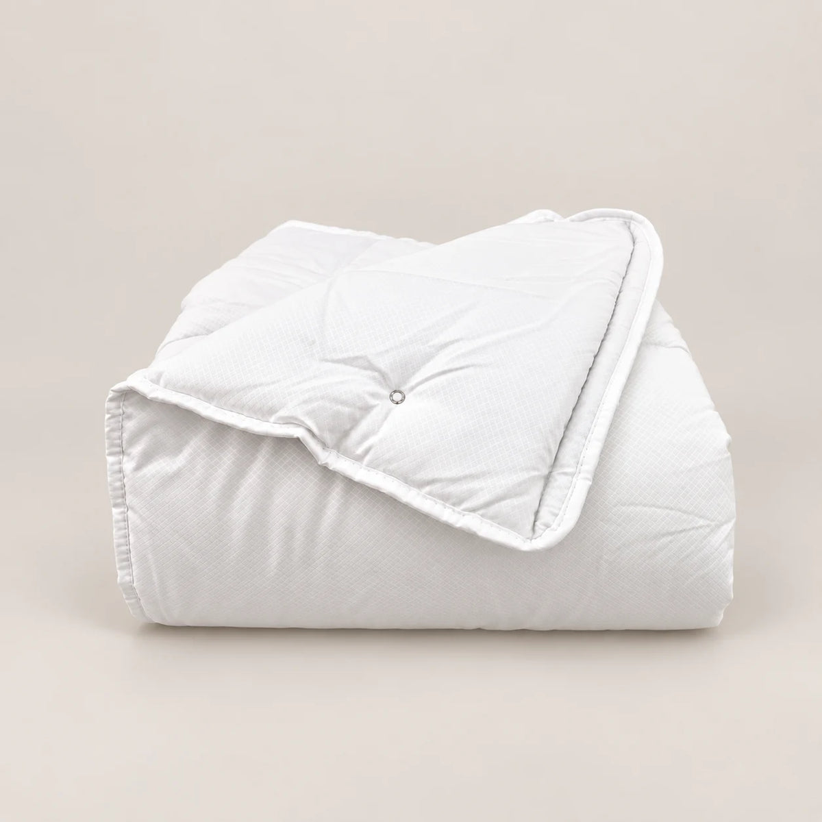 Couette Eco 250 g pliée, montrant l’angle cousu. - Oma Home