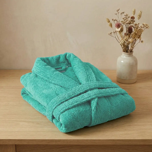 Primer plano del tejido de algodón peinado del albornoz turquesa, mostrando su suavidad y acabado premium sin impurezas.