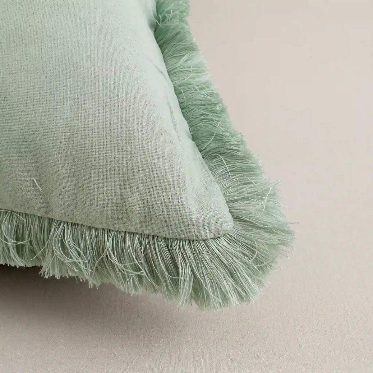 Primer plano del tejido extrasuave y transpirable 100% algodón de la funda de cojín verde de Oma Home.