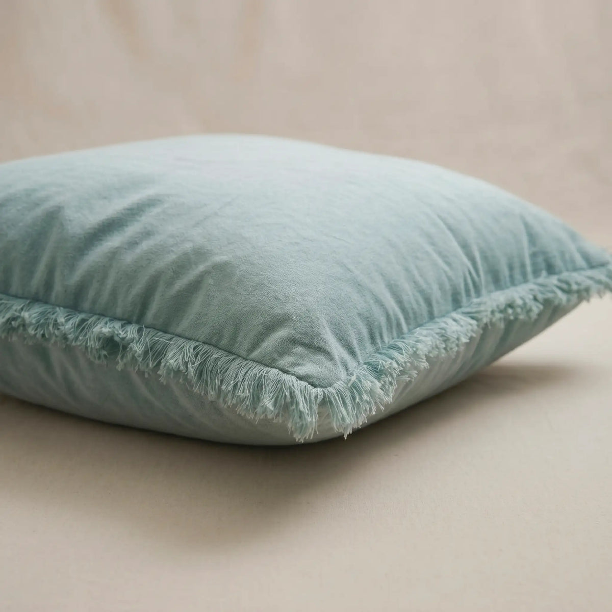 Primer plano del tejido extrasuave y transpirable 100% algodón de la funda de cojín azul claro de Oma Home.